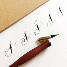 a fountain pen and some calligraphy on a sheet of paper