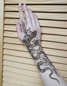 a woman's hand with hennap on it and an intricate tattoo design