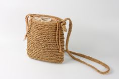 This bag is handwoven by lucielalune studio, made of 100% raffia straw yarn, and linen cotton fabric. It is the perfect summer accessory to be used out in the city or to spend a day at the beach. Intern lining is made in crepe linen Cotton fabric , fixed by sewing with the raffia woven part. There are 2 small pockets integrated inside of lining for pens or little things. The size of bag is well designed for phones, keys, glasses, other small things... - Cotton dia 6mm drawstring closure - Adjust Natural Straw Shoulder Bag With Weaving, Natural Weaving Straw Shoulder Bag, Summer Travel Crochet Bag With Weaving Detail, Summer Travel Crochet Bag, Summer Travel Crochet Weaving Bag, Casual Straw Beach Bag With Weaving, Casual Natural Straw Bag With Weaving, Casual Straw Bag With Weaving For Beach, Casual Weaving Straw Bag For Beach