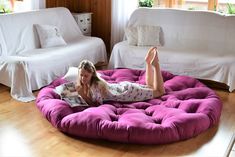 a woman laying on top of a bean bag chair