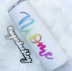 a white tumbler with the word sparkle painted on it next to a candy bar