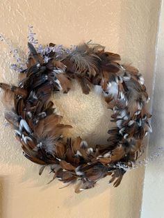 a wreath with feathers hanging on the wall