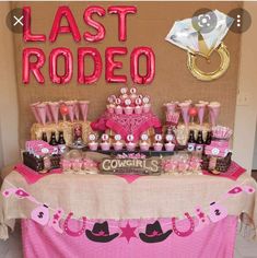 a table topped with lots of pink and gold items next to a sign that says last rodeo