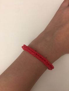 a person wearing a red bracelet on their wrist