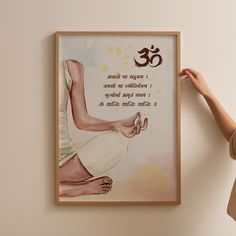 a woman is holding up a framed poster with an om shanti quote on it