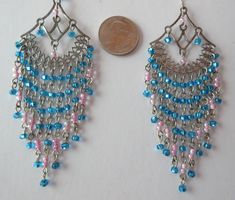 These earrings are made with a fan style with glass beads linked together with 20 g silver plated wire... They are made with 4mm glass beads...  The colors are blue and pink glass beads which hang in wire links from the fan style... Measurements of the earrings are 4 inches long by 1 1/2 inches wide and the ear hooks are silver plated wires... Any questions, please e-mail me.... Blue Metal Beaded Earrings With Colorful Beads, Silver Beaded Chain Earrings, Blue Metal Beaded Earrings Wire Wrapped, Blue Wire Wrapped Beaded Metal Earrings, Blue Beaded Metal Chandelier Earrings, Silver Beaded Metal Earrings, Silver Chandelier Earrings With Colorful Beads, Silver Chandelier Earrings With Colorful Beads As Gift, Silver Wire Wrapped Czech Glass Beaded Earrings