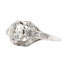 This antique piece was handcrafted sometime during the Edwardian design period (1900-1920). The incredible platinum setting features a center diamond measuring approximately 0.90 carats. The center diamond is an Old European cut. The diamond grades approximately J in color and SI1 in clarity. The platinum setting features intricate open work filigree accented beautifully by 18 sparkling diamond accents. The solitaire style features antique hand engravings and minimal milgrain accents. This plati Old European Cut Engagement Ring, Edwardian Design, Sparkling Diamond, Filigree Ring, Sparkle Diamonds, Hand Engraving, Jewelry Rings Engagement, Ring Verlobung, Platinum