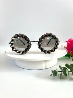 Silver spiked punk statement  sunglasses. These studded round sunglasses are simple yet make a huge statement to your outfits. The frames are light weight and they have silver mirrored lenses. All around the frames are charcoal colour studs giving them a gophic edgy look. Great for raves, festivals, carnivals, holidays or everyday wear if that's your thing 😉 UV protection. All my glasses come in a black pouch to keep them safe, please also handle with care. Checkout the full collection of Sunnies here :  https://www.etsy.com/uk/shop/AlexisExclusive?ref=s2-header-shopname ✨Find us on Instagram: https://www.instagram.com/AlexisExclusive To be kept up to date with new designs please FAVORITE MY SHOP. Punk Style Mirrored Sunglasses For Summer, Adjustable Punk Sunglasses For Summer, Adjustable Punk Style Sunglasses For Summer, Punk Style Adjustable Sunglasses For Summer, Trendy Silver Round Frame Sunglasses, Punk Style Tinted Sunglasses For Parties, Edgy Sunglasses With Mirrored Lenses For Party, Edgy Party Sunglasses With Mirrored Lenses, Trendy Metal Sunglasses For Festivals