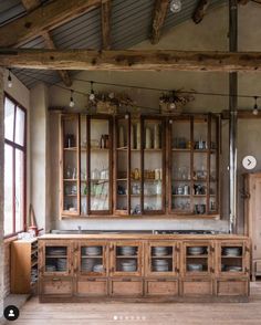 an old fashioned kitchen with wooden cabinets and dishes