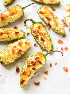 bacon stuffed jalapeno peppers on a white counter top with other toppings