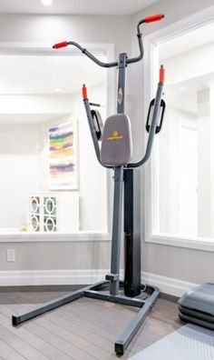 a home gym with an exercise machine in the corner and other equipment on the floor