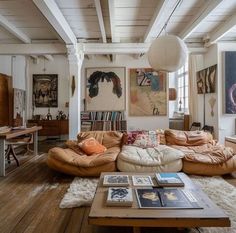 a living room filled with furniture and pictures on the wall next to a coffee table