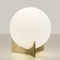 a white ball sitting on top of a metal stand next to a light that is turned on