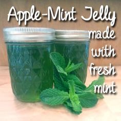 two mason jars filled with fresh minty liquid on top of a wooden table next to the words apple - mint jelly made with fresh mint