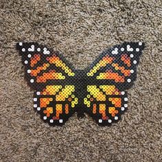 a close up of a butterfly made out of perforated material on the ground