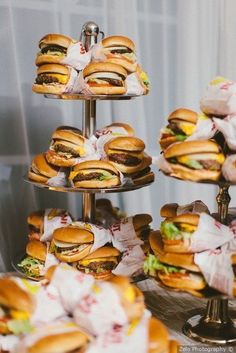 several sandwiches are stacked on three tiers with wrappers around them and wrapped in white paper