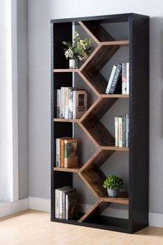 a bookshelf with several shelves and plants in it on the floor next to a wall