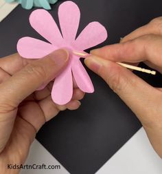 someone is making a flower out of paper