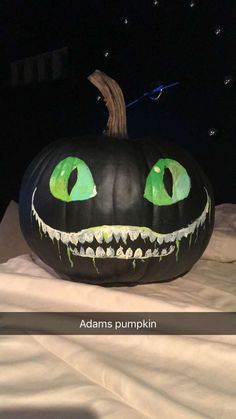 a pumpkin with green eyes painted on it