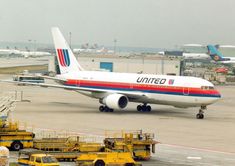 an airplane is parked on the tarmac with other vehicles around it and some planes in the background