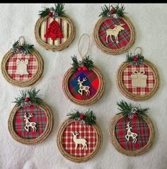 christmas ornaments are hanging from twine baskets on a white sheet with red and green plaid designs