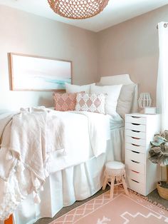 a white bed sitting in a bedroom next to a pink rug on top of a floor