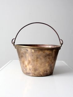 a metal bucket sitting on top of a white table