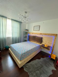 a bed room with a neatly made bed next to a window and a rug on the floor