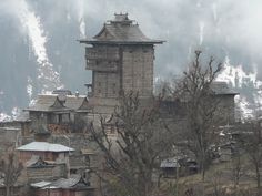 an old wooden building on top of a hill