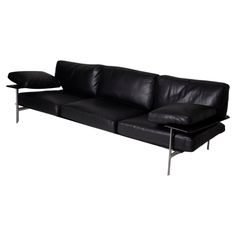 a black leather couch sitting on top of a white floor