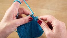 someone is knitting something with yarn on the table