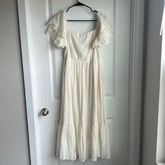 Mid Length White Dress From Four Sisters Boutique In Omaha. Would Be Perfect For Bridal Events. Cream Flowy Cotton Midi Dress, Flowy Cream Cotton Midi Dress, White Short-sleeved Maxi Dress With Ruffles, White Ruffled Short Sleeve Maxi Dress, Cream Summer Midi Dress For Brunch, Cream Sundress Maxi Dress For Daytime, Cream Sundress Midi Dress For Brunch, White Summer Midi Dress With Ruffles, White Ruffled Summer Midi Dress