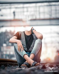 a young man sitting on the ground with his hands behind his head, wearing sandals