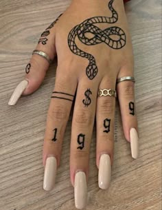 a woman's hand with tattoos on it and numbers painted on her fingers,