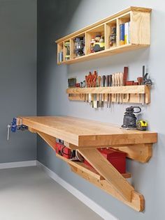 a workbench with tools on it and shelves in the wall next to it