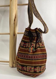 Peruvian Handmade Bucket Style Crossbody Bag in Brown This is a simple and fun handmade bucket bag from Peru.  It is made of lightweight Andean fabric (not thick wool) in a dark brown with designs common to Peruvian style.   Perfect fall colors!  Please note handcrafted items may have stray threads.   Features *Tie closure Specifications *Approximate Dimensions:  14.5" Height | 9" Diameter  Materials *Andean Textile HANDCRAFTED IN PERU Brown Bucket Hobo Bag For Daily Use, Casual Brown Woven Bucket Bag, Brown Bucket Hobo Bag With Adjustable Strap, Casual Brown Handwoven Bag, Casual Brown Bucket Bag, Bohemian Brown Woven Shoulder Bag, Casual Brown Handmade Shoulder Bag, Bohemian Large Capacity Pouch Bucket Bag, Everyday Brown Woven Bucket Bag