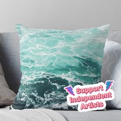 a pillow sitting on top of a couch next to a pillow case with the words support independent artists