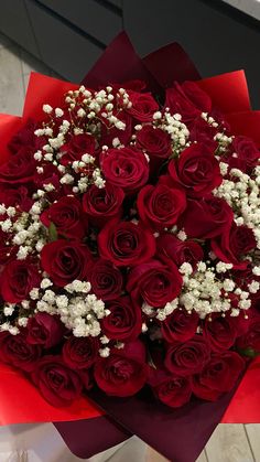 a bouquet of red roses with baby's breath