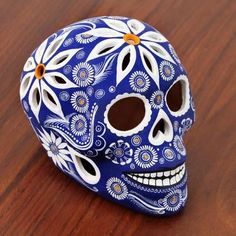 a blue and white skull sitting on top of a wooden table