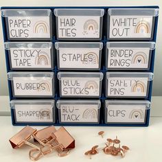 several stacks of paper clips next to each other on top of a white table with blue bins