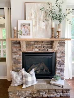 a living room with a fire place and pictures on the mantle