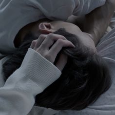 a man laying in bed with his head on the pillow