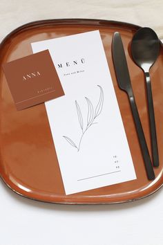 an empty plate with utensils and menu on it