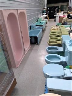 a row of toilets sitting next to each other in a room with lots of different colors