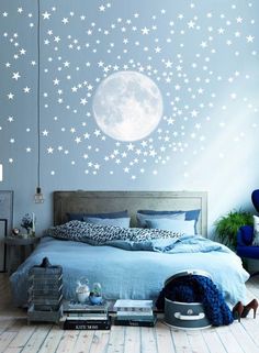 a bed room with a neatly made bed and stars on the wall next to it