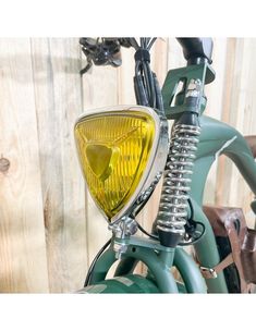 a green bicycle with a yellow light on the front