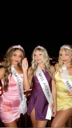 three beautiful young women standing next to each other