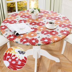 a round table with flowers on it in front of a window and two white chairs