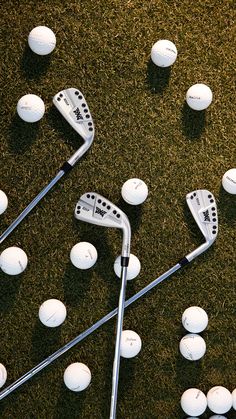 several golf clubs and balls laying on the ground in front of each other with holes to put them in