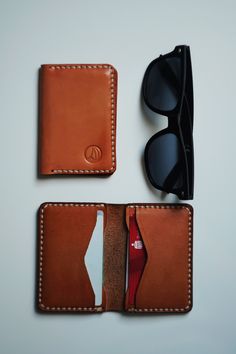 two wallets with sunglasses on top of them next to each other and a pair of glasses